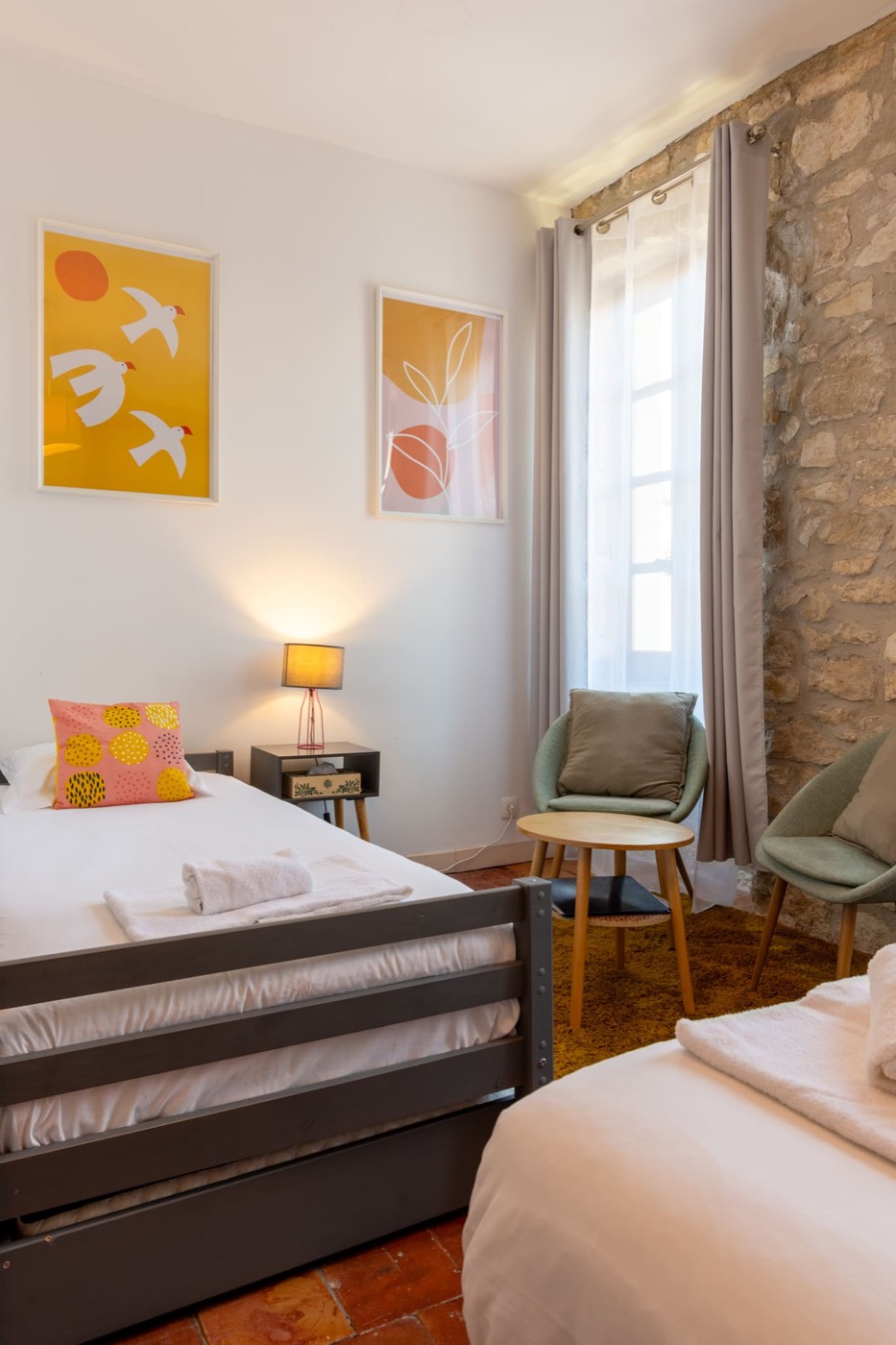 Deluxe-Dreibettzimmer mit bunten Plakaten und Sesseln