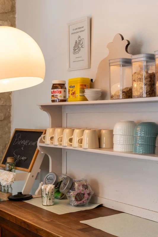 Coin petit-déjeuner avec bols, tasses, céréales et confitures